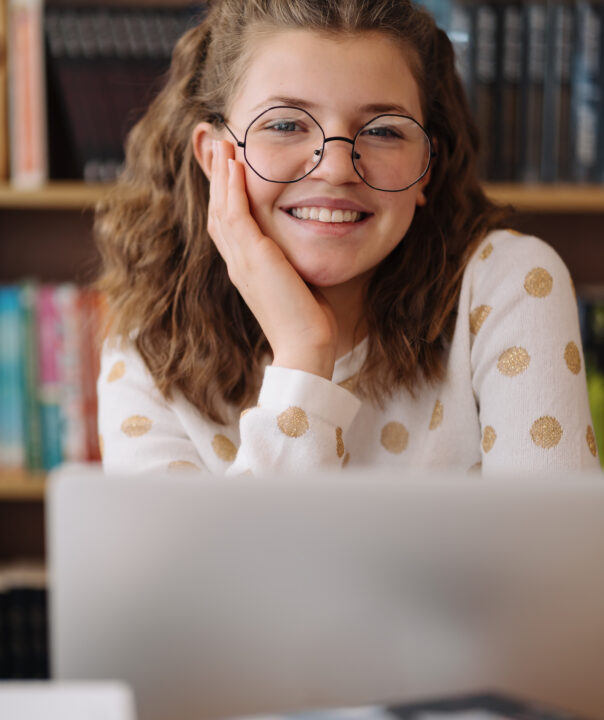 Girl studying among books using laptop