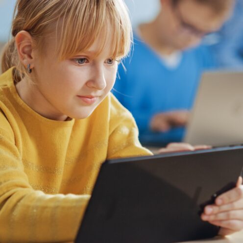 girl-sits-desk-with-tablet-front-her